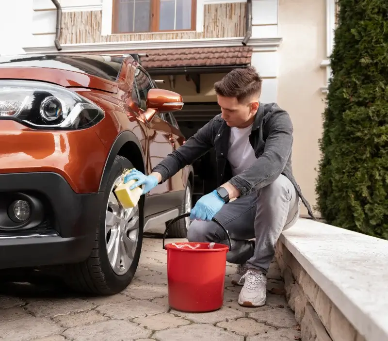 Lavage auto à domicile Courtonne-la-Meurdrac : professionnel intervenant sur un véhicule